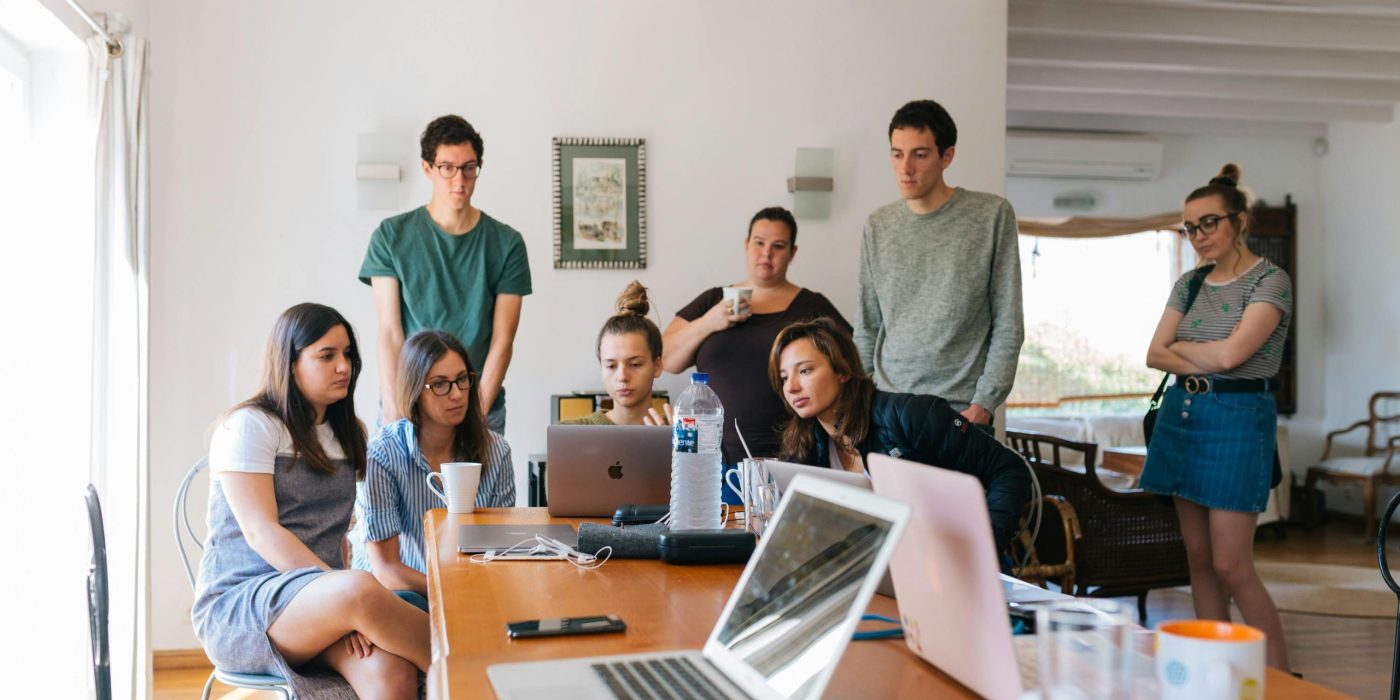 Group of young professionals engaged in a collaborative meeting in a modern office setting.